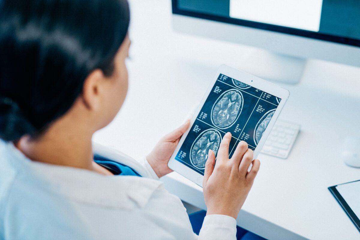 Doctor looking at a tablet with a brain scan on the screen