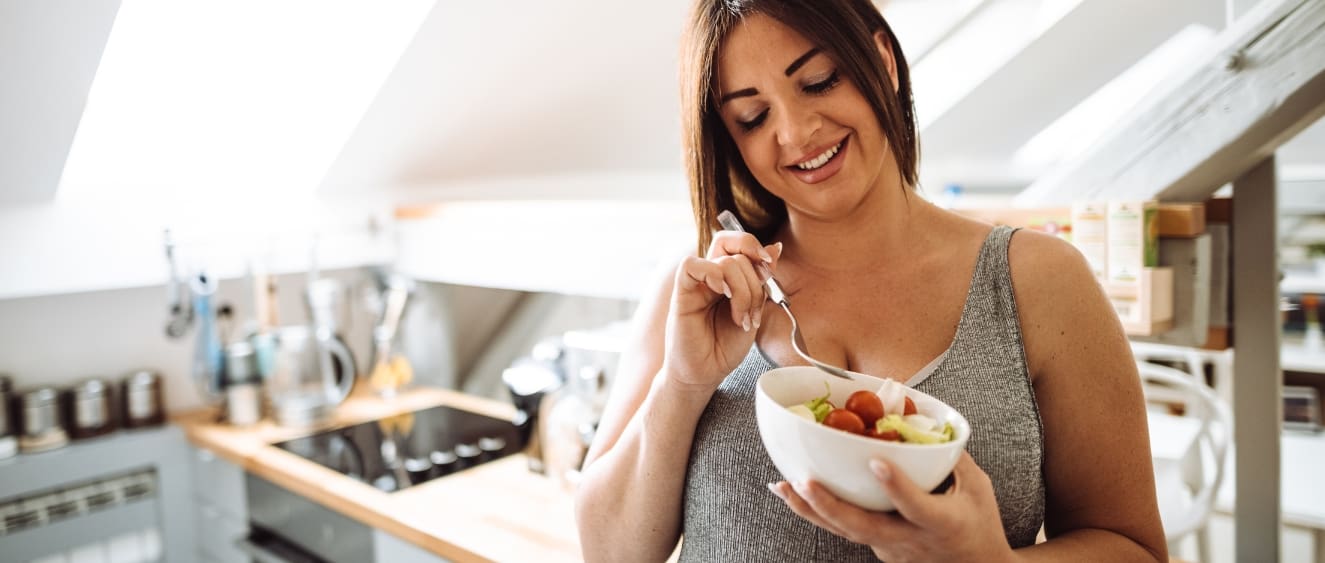 overweight woman eating a healthy, balanced snack